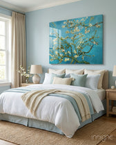 Almond Blossom glass wall art displayed above a bed in a soft-blue bedroom