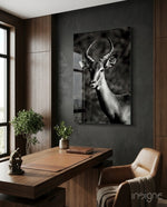 Impala glass wall art displayed above a wood desk in a charcoal-walled office