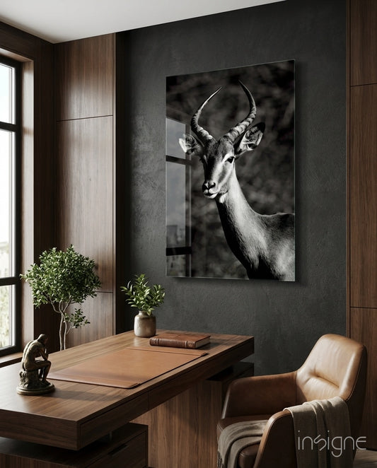 Impala glass wall art displayed above a wood desk in a charcoal-walled office
