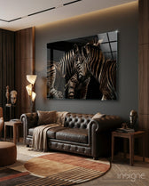 Zebras glass wall art displayed above a leather chesterfield in a wood-paneled lounge
