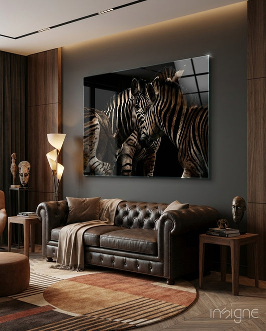 Zebras glass wall art displayed above a leather chesterfield in a wood-paneled lounge