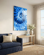 Blue Tie Dye glass wall art displayed above a navy linen sofa in a coastal living room