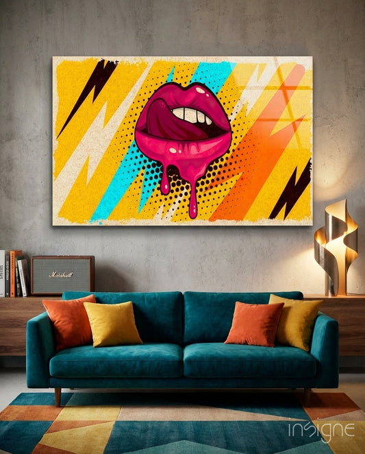 Pop Lips glass wall art displayed above a teal velvet sofa in a creative loft