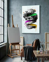 David Slices glass wall art displayed above an easel in a concrete art studio