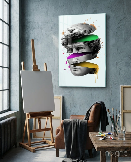 David Slices glass wall art displayed above an easel in a concrete art studio