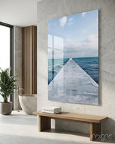 Pier Horizon glass wall art displayed above a wood bench in a stone-tiled spa bathroom