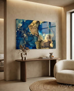 Cobalt Gold Tide glass wall art displayed above a walnut console in a warm beige hallway
