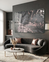Smoke and Blush glass wall art displayed above a curved grey velvet sofa in a charcoal-walled lounge