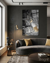 Charcoal Lightning glass wall art displayed above a curved grey velvet sofa in a charcoal-walled lounge