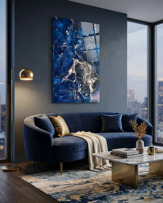 Royal Cliff glass wall art displayed above a curved navy velvet sofa in a charcoal city-view lounge
