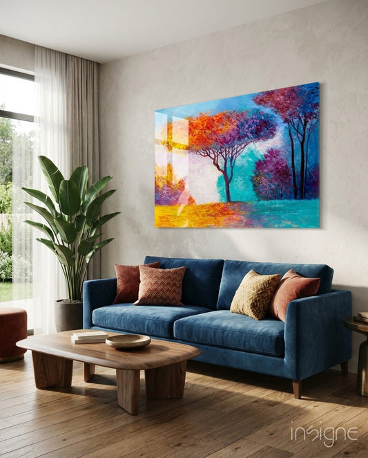 Autumn Pines glass wall art displayed above a blue velvet sofa in a bright contemporary living room