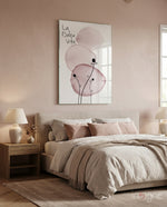 La Dolce Vita glass wall art displayed above a linen-upholstered headboard in a blush-walled bedroom