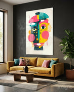 Pop Face glass wall art displayed above a mustard velvet sofa in a charcoal-walled lounge