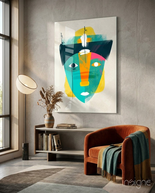 Tribal Mask glass wall art displayed above a wood console in an industrial concrete lounge with cognac armchair