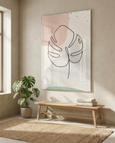 Line Monstera glass wall art displayed above a wood bench in a warm beige minimalist hallway