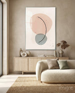 Peach Arc glass wall art displayed above a wood credenza in a warm sandstone lounge with bouclé sofa