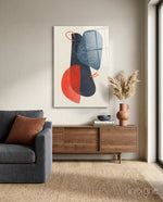 Mid-Century Forms glass wall art displayed above a wood credenza in a warm minimalist living room with charcoal sofa