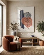 Fern Stack glass wall art displayed above a wood credenza in a warm beige minimalist nook with rust velvet armchair
