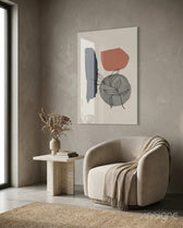 Leaf Circle glass wall art displayed above a travertine side table in a warm earth-toned lounge with bouclé chair
