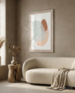 Seated Line glass wall art displayed above a curved bouclé sofa in a warm earth-toned lounge