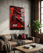 Red Stairs glass wall art displayed above a brown leather sofa in an industrial brick-walled lounge