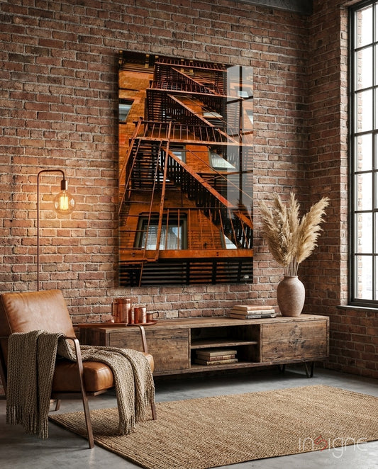 Orange Stairs glass wall art displayed above a brown leather chair against a brick wall in a contemporary urban lounge