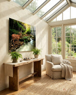 Forest Deer glass wall art displayed above a rustic wood console in a bright sunroom with bouclé chair