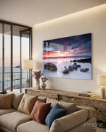 Beach Sunset glass wall art displayed above a wood low credenza in a bright modern coastal living room with linen sectional