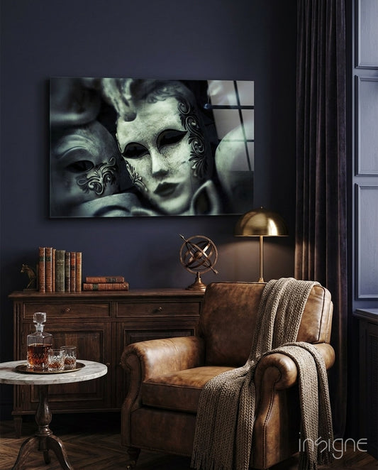 Venetian Masks glass wall art displayed above a wood credenza in a dark navy lounge with brown leather chair