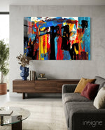 Festival Walk glass wall art displayed above a walnut credenza in a warm concrete-walled lounge with charcoal sofa