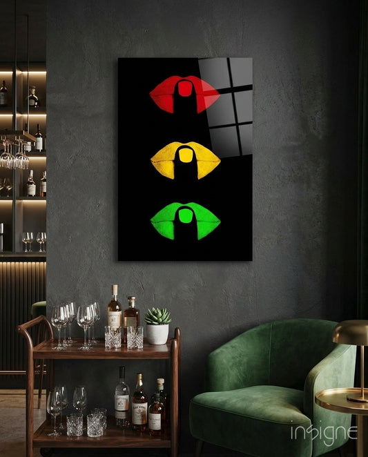 Lip Signal glass wall art displayed above a wood bar cart in a charcoal-walled lounge with emerald velvet armchair