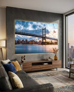 Triboro Bridge glass wall art displayed above a walnut credenza in a warm grey city-view lounge with charcoal sectional