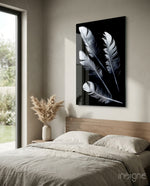 White Feathers glass wall art displayed above a wood-headboard bed in a warm beige minimalist bedroom