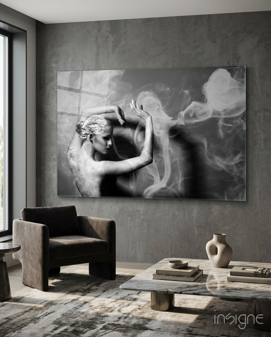 Smoke Dancer glass wall art displayed above a marble coffee table in an industrial concrete-walled lounge with charcoal armchair