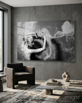 Smoke Dancer glass wall art displayed above a marble coffee table in an industrial concrete-walled lounge with charcoal armchair