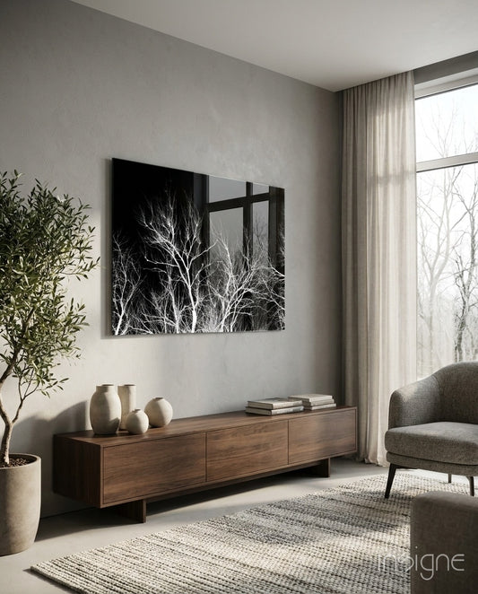Night Trees glass wall art displayed above a walnut credenza in a warm minimalist living room with charcoal armchair