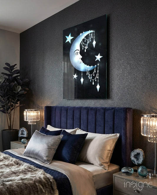 Crescent Garland glass wall art displayed above a navy velvet headboard in a dark moody bedroom with crystal lamps