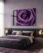 Purple Rose glass wall art displayed above an upholstered headboard in a lavender-walled bedroom with purple bedding