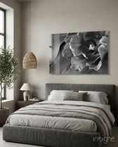 Monochrome Tulip glass wall art displayed above a charcoal upholstered headboard in a warm beige minimalist bedroom
