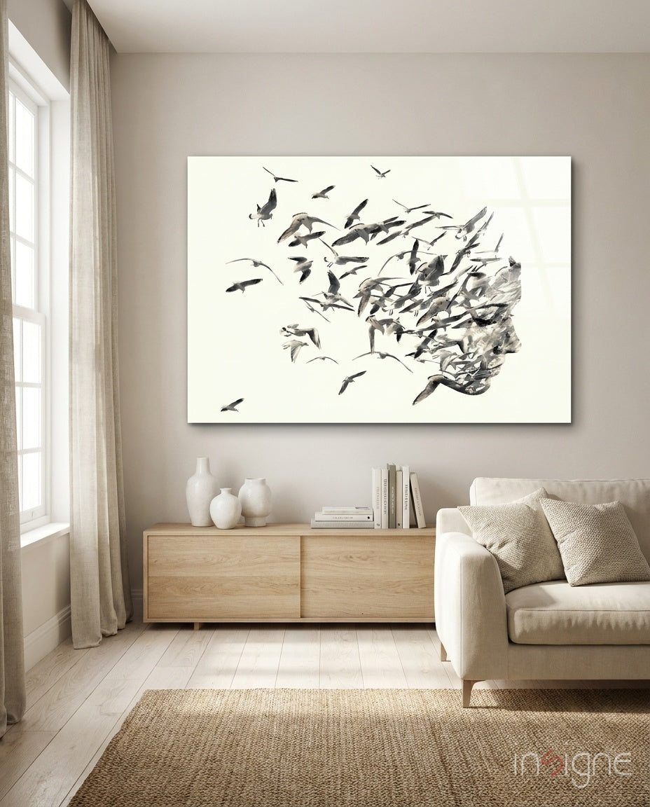 Bird Thoughts glass wall art displayed above a wood credenza in a warm beige minimalist living room with linen sofa