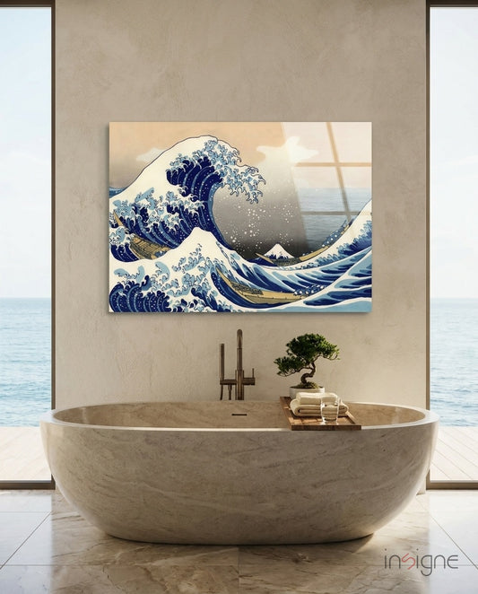 Great Wave glass wall art displayed above a stone tub in a warm sandstone-walled spa bathroom with ocean view