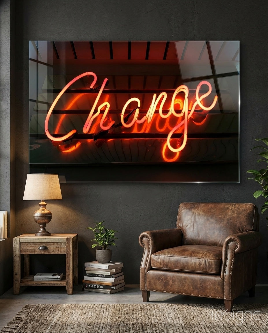 Change Neon glass wall art displayed above a wood side-table in a dark grey lounge with brown leather chair