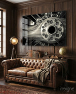 Vintage Engine glass wall art displayed above a brown chesterfield sofa in a dark wood-paneled lounge with brass tripod lamp