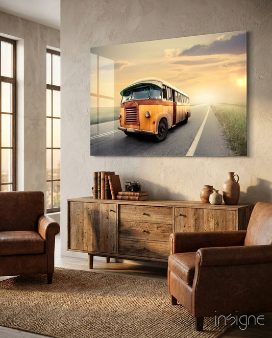 Caravan Sunset glass wall art displayed above a wood credenza in a warm sandstone-walled lounge with brown leather chairs