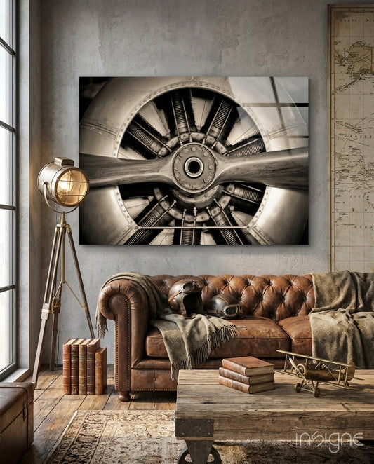 Vintage Propeller glass wall art displayed above a brown chesterfield sofa in an industrial stucco-walled lounge with map and brass tripod