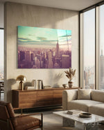 Manhattan Dawn glass wall art displayed above a walnut credenza in a warm minimalist concrete-walled lounge with linen sectional and city view