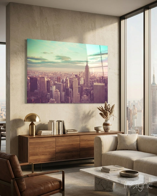 Manhattan Dawn glass wall art displayed above a walnut credenza in a warm minimalist concrete-walled lounge with linen sectional and city view
