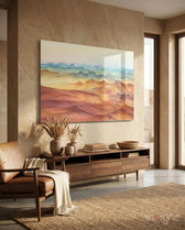 Watercolor Ranges glass wall art displayed above a walnut credenza in a warm sandstone-walled lounge with cognac chair