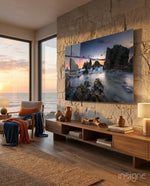 Coastal Cliffs glass wall art displayed above a wood credenza in a stone-walled coastal lounge with cognac chair and ocean view