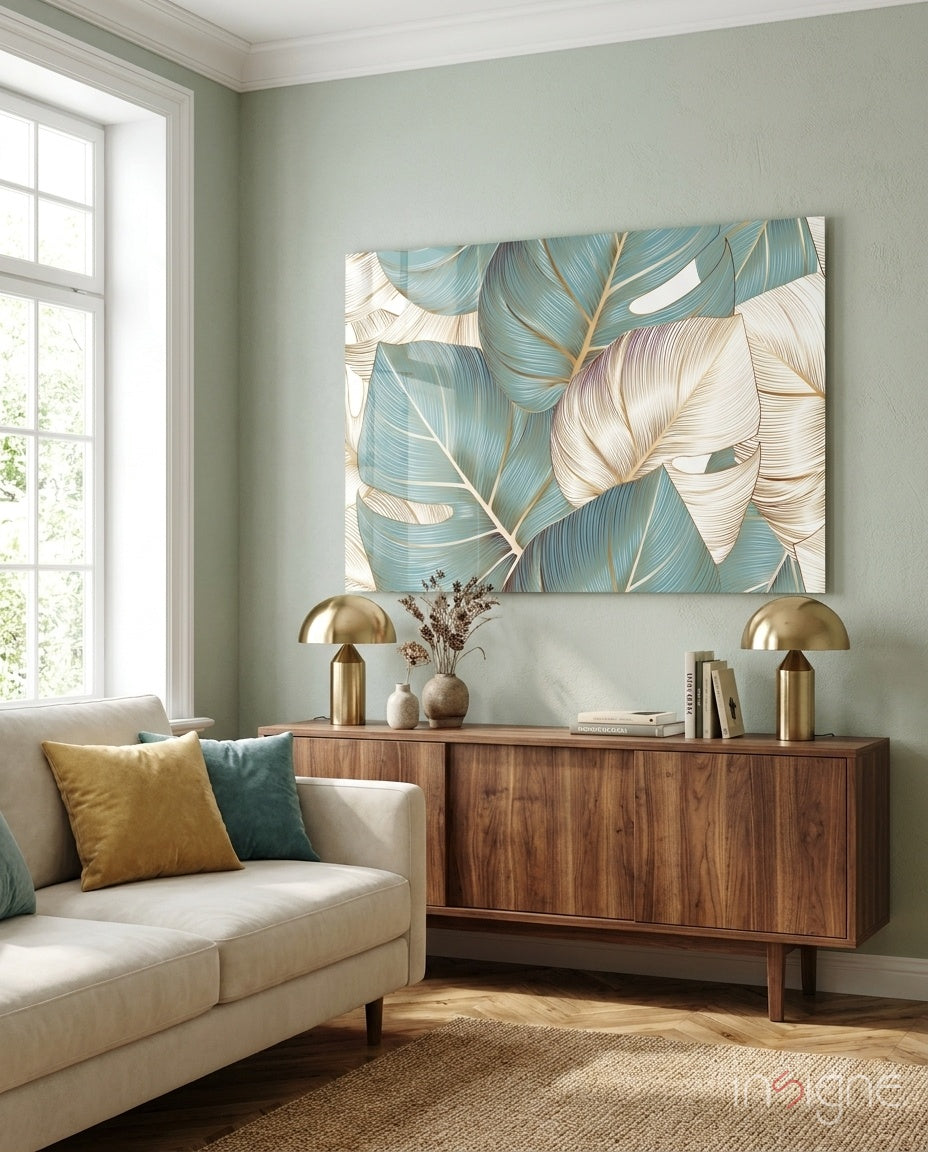 Leaves glass wall art displayed above a walnut credenza in a soft sage-walled living room with cream sofa and brass lamps